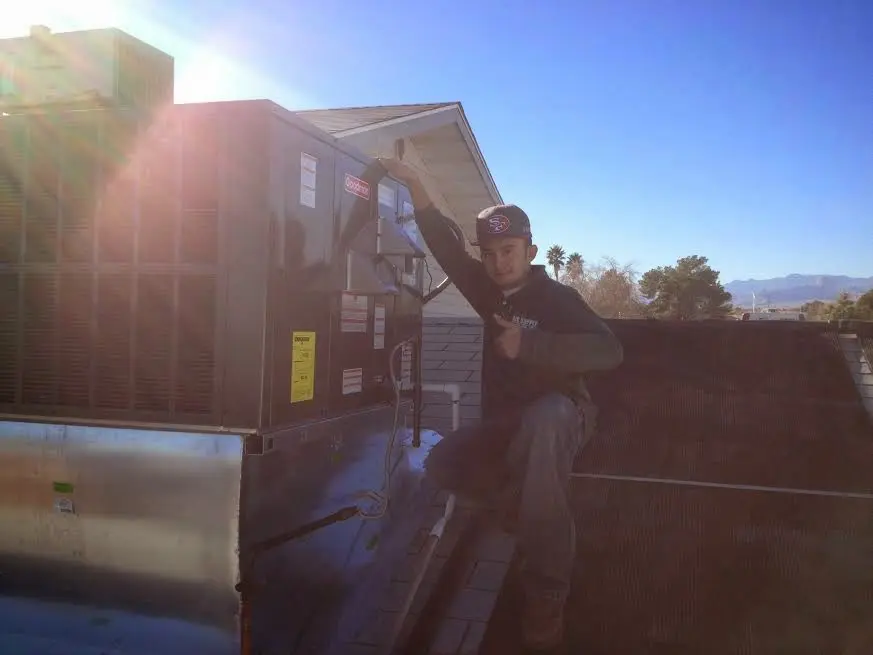 HVAC technician performing Boiler Repair on a rooftop unit in Acton